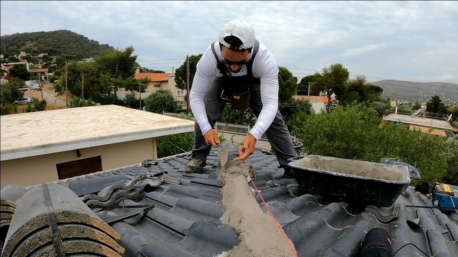 The founder working on a roof ridge, hands on the material, in working clothes