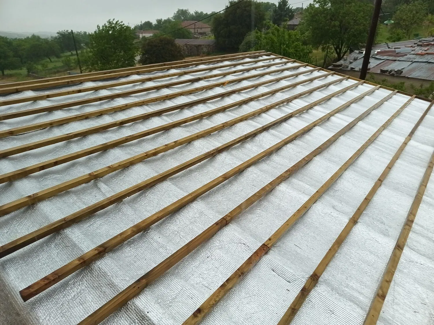 The reflective membrane and tile battens, with the village landscape behind