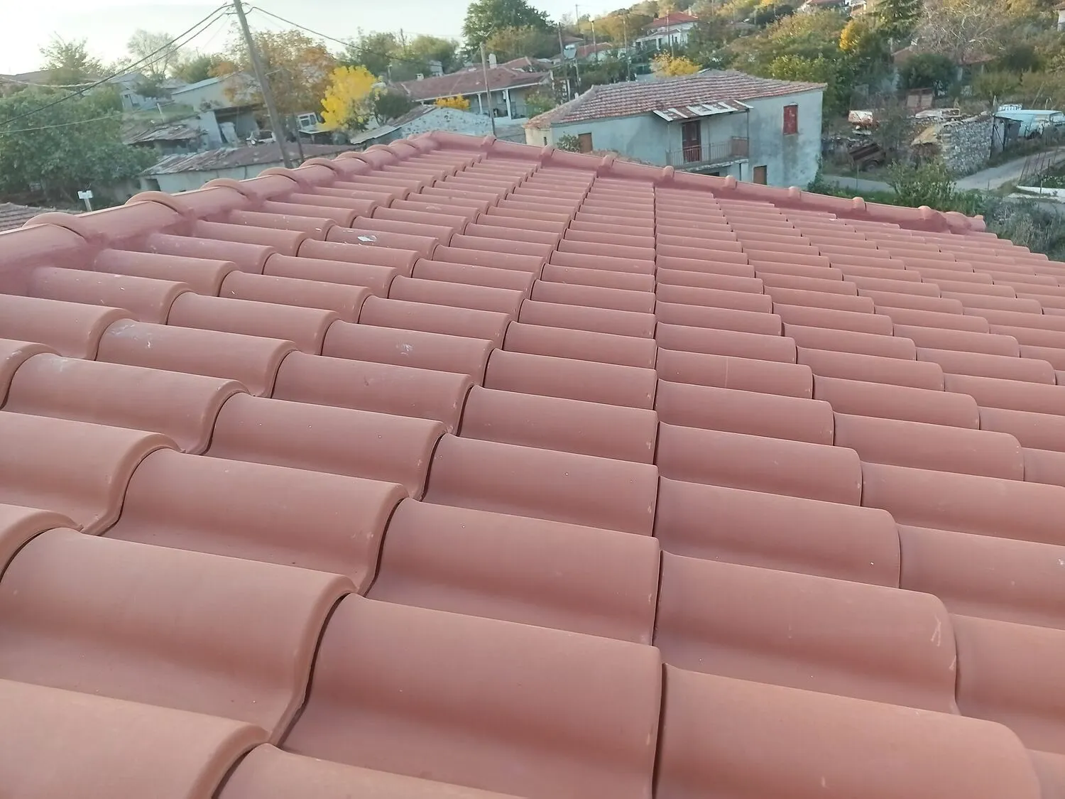 The completed roof in autumn light with village foliage