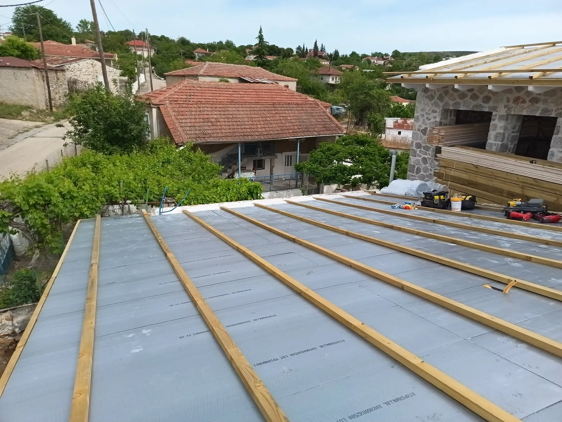Continuous XPS insulation boards laid unbroken across a roof plane with new timber counter-battens fixed over them